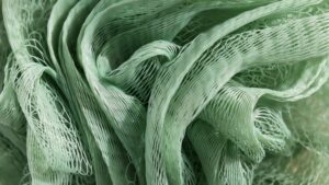 Close-up of flexible green nylon polyamide mesh with overlapping netted strands, showing the material’s fine texture and open structure.