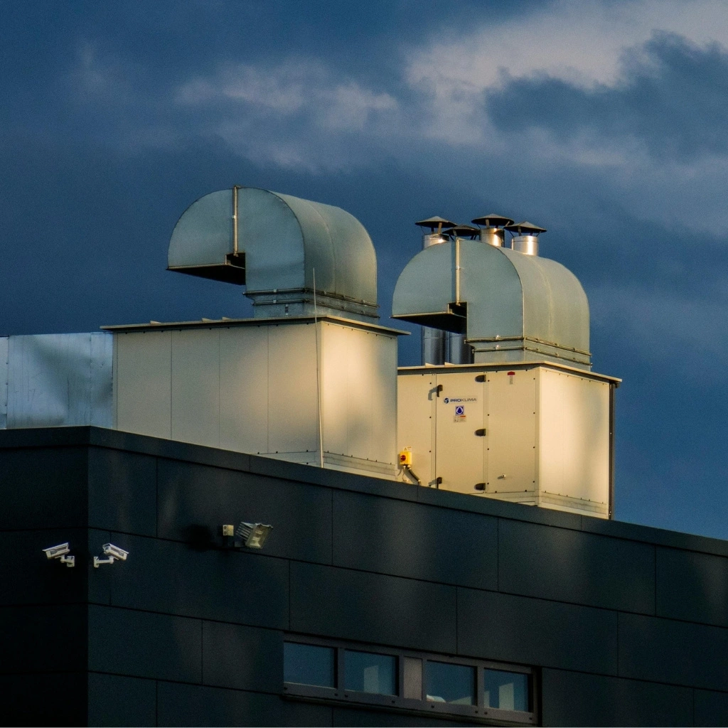 Rooftop HVAC units with large ventilation ducts installed on an industrial or commercial building.