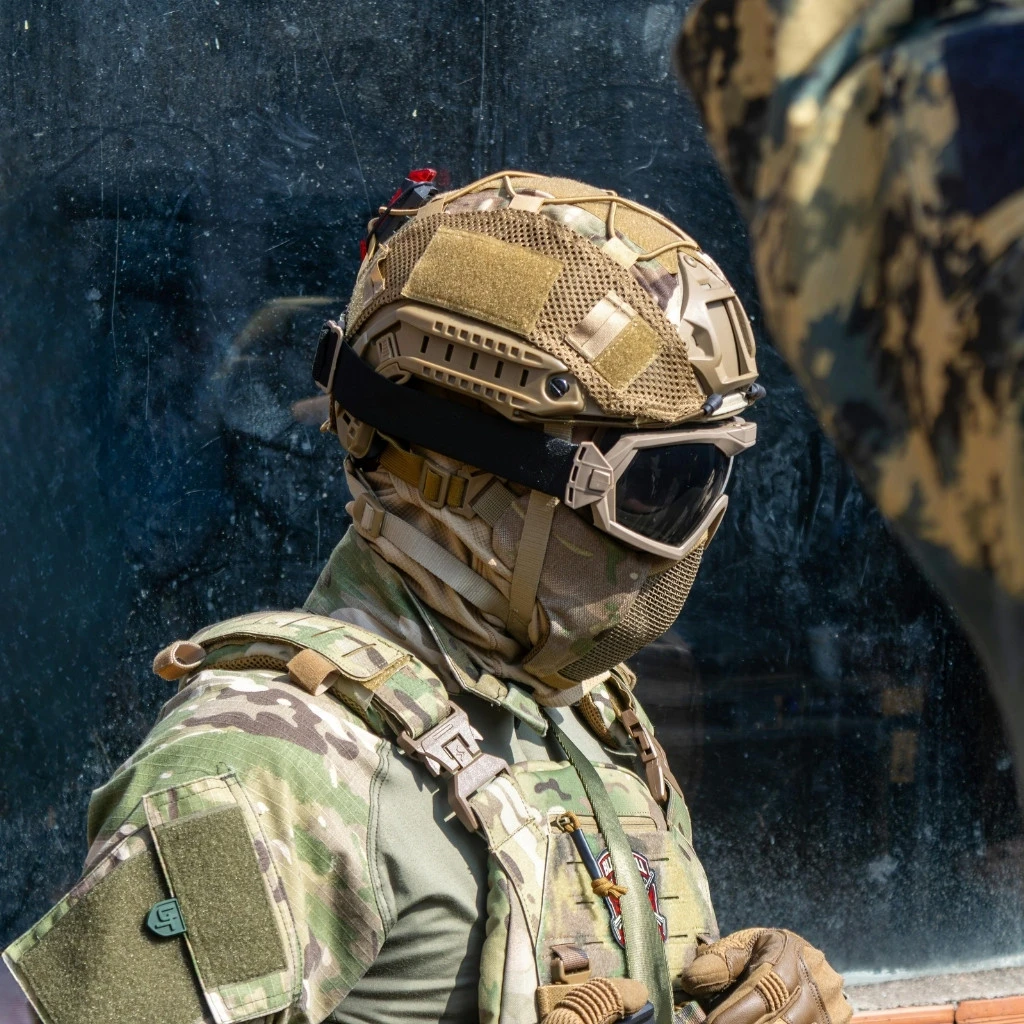 Military protective gear with molded plastic helmet, eyewear, and tactical equipment components