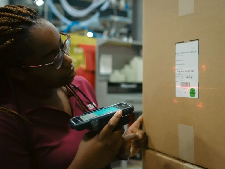 Texas Injection Molding team member scanning a packaged shipment for warehouse quality control and logistics