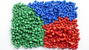 Green, blue, and red plastic resin pellets used for injection molding material selection