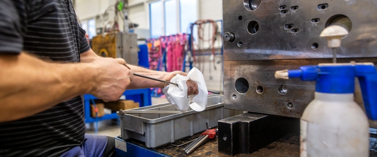 Toolmaker preparing an injection mold during surface finishing and maintenance