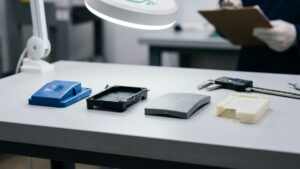 Injection molded plastic parts with sink marks, flash, warpage, and a short shot arranged for quality inspection.