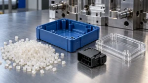 Thermoplastic resin pellets beside a blue molded enclosure, black connector, and clear plastic cover, with steel tooling behind them.